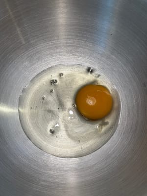 首先，在一個攪拌碗中，將雞蛋和溫牛奶混合均勻。