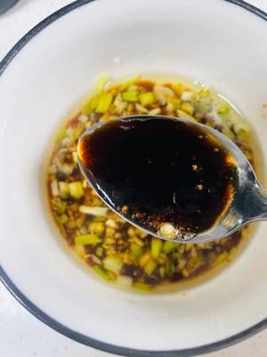1. Prepare la salsa en un bol con ajo picado y cebolleta picada. Vierta una cantidad adecuada de aceite de cocina en la olla, caliéntelo a fuego lento hasta que humee ligeramente y luego vierta con cuidado el aceite caliente sobre el ajo picado y la cebolleta picada para estimular el aroma de ambos.
2. Añada 1 cucharada de salsa de soja, 1 cucharada de salsa de ostras, media cucharada de azúcar y 1 cucharada de vinagre añejo al bol. Remueva bien con palillos chinos o una cucharilla para integrar bien los condimentos y reserve para usar más adelante.