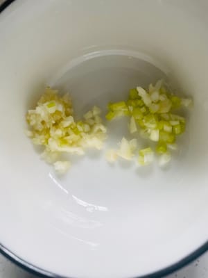 Selezionare la quantità adeguata di cipollotto e tagliarlo a pezzetti; tritare l'aglio fino a ottenere una pasta fine e metterla in una ciotola per un uso successivo.