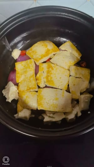 เทส่วนผสมทั้งหมดจากกระทะลงในหม้อขนาดเล็กแล้วเกลี่ยให้ทั่ว วางเต้าหู้ทอดลงบนหัวหอม แล้วโรยเกลือเล็กน้อยเพื่อเพิ่มรสชาติ สุดท้าย เทปลาที่หมักไว้และน้ำหมักลงไป แล้วเกลี่ยให้ทั่ว