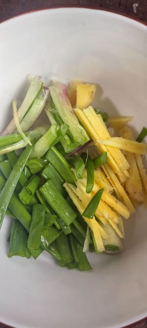 หั่นขิงเป็นเส้นบางๆ หั่นต้นหอมเป็นท่อนยาวๆ และหั่นเต้าหู้เป็นชิ้นๆ สับหัวหอมครึ่งหัวเป็นชิ้นใหญ่ๆ และสับพริกและกระเทียมเป็นชิ้นเล็กๆ