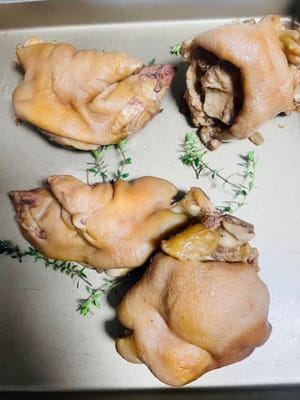 Para hornear, forra una bandeja para hornear con tus hierbas favoritas (como tomillo o romero, pero no te preocupes si no las tienes) y coloca las manitas de cerdo extendidas sobre ella.

Espolvorea las manitas de cerdo con tus condimentos favoritos: comino en polvo, salsa seca para mojar, mezcla de cinco especias, etc., y espolvorea con semillas de sésamo blanco. ¡El aroma será tan tentador que tus vecinos vendrán a tocar a tu puerta!