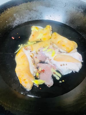 Escaldar para eliminar el olor a pescado. Colocar las patas de cerdo lavadas en una olla con agua fría, añadir unas rodajas de jengibre, un poco de vino de cocina y un puñado de granos de pimienta (o cebolletas). Cuando el agua hierva, cocinar durante 5 minutos para eliminar la espuma de sangre. Retirar, enjuagar con agua tibia y escurrir.