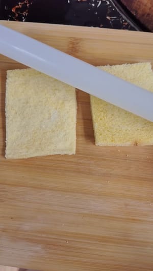 パンの四辺を切り落とし、麺棒を使って薄くスライスします