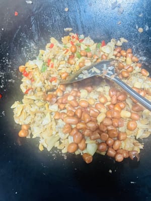 Aggiungere le arachidi fritte e saltare in padella velocemente e in modo uniforme per amalgamare la croccantezza delle arachidi con il sapore della polpa di vongole e del ravanello essiccato. Spegnere il fuoco dopo aver saltato in padella alcune volte e servire le vongole fritte su un piatto. Le deliziose vongole fritte sono pronte.