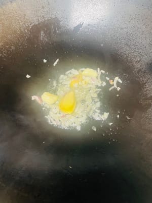 Soffriggere la base: Versare l'olio in una padella, aggiungere lo zenzero affettato, la cipolla tritata e l'aglio a fuoco basso e soffriggere fino a quando la cipolla non diventa trasparente e l'aglio non è leggermente dorato.