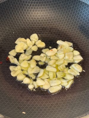 Aggiungere l'aglio affettato e abbassare la fiamma. Continuare a rosolare l'aglio per circa 2 minuti.