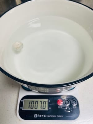 1000克28-30度溫度的水加入1粒酒麯，泡一會用手搓散它，以便與糯米飯更好拌均勻。