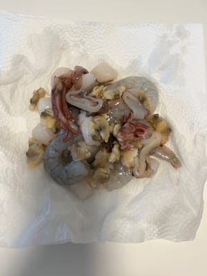 Lavar los mariscos variados y escurrir la humedad con papel de cocina.