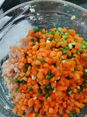 dann die geschnittenen Karotten und Frühlingszwiebeln hinzufügen