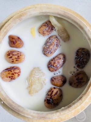 Ingwerscheiben, rote Datteln und Fischmagen in einen Schmortopf geben, 500–600 ml frische Milch mit einem Proteingehalt von mindestens 3,6 g hinzufügen und 50–60 Minuten köcheln lassen. Das fertige Produkt ist reich an Kollagen und köstlich.