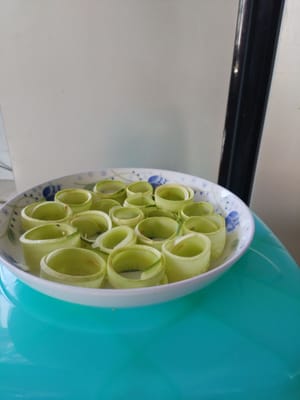 Cut the cucumber slices in half, roll them into a round shape and place them on a plate.