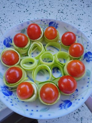 Place the cherry tomatoes on the outside of the cucumber ring on the plate