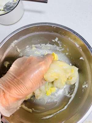 準備麻薯餡:
趁麵團發酵的空檔,咱們嚟搗鼓靈魂麻薯!把糯米粉、玉米澱粉、牛奶、白糖攪和均勻,別留顆粒最好過個篩,然後上鍋隔水蒸15-20分鐘,蒸到完全冇乾粉就收手。記得蓋層保鮮膜或蓋子,別讓水蒸氣滴進去毀了我的麻薯寶貝!蒸好後趁熱加軟化的黃油抓勻,分成6等份,麻薯基底就搞定啦~