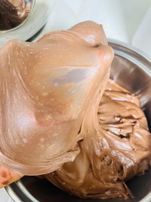 把軟化的牛油加進去,低速揉3分鐘讓牛油全融進麵團,再高速揉8分鐘,直接揉出薄溜溜的手套膜