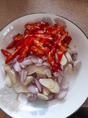 Tagliare finemente l'aglio, lo scalogno e i peperoncini rossi.