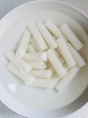 Weichen Sie den Reiskuchen 30 Minuten in Wasser ein, um ihn zum Braten weich zu machen.