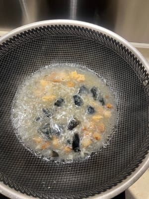 Luego agregue la yema de huevo salada y el jengibre y hierva hasta que la sopa se vuelva ligeramente blanca.