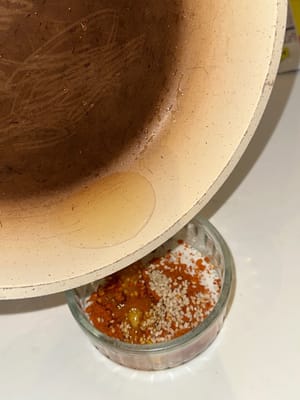 Préparez l'assaisonnement des nouilles en versant de l'huile chaude dans de la poudre de piment et des graines de sésame