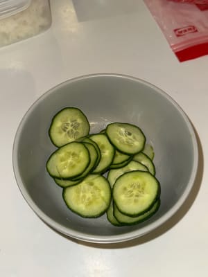 將黃瓜切成薄片，放入碗中，加入適量鹽，攪拌均勻。靜置15分鐘，然後用水沖洗黃瓜，瀝乾水分後，放在米飯上。