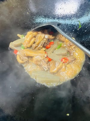 In einem anderen Wok etwas Öl erhitzen und die gewürfelten grünen und roten Chilischoten sowie den gehackten Knoblauch anbraten. Die geschmorte Ente hinzufügen und vor dem Servieren kurz anbraten.