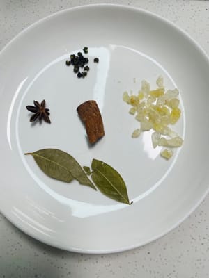 Gewürze und Kandiszucker vorbereiten:
Die Gewürze (Lorbeerblätter, Sternanis, Zimt und Sichuan-Pfefferkörner) sammeln und gründlich mit Wasser abspülen. Außerdem einige Stücke Kandiszucker bereitstellen.