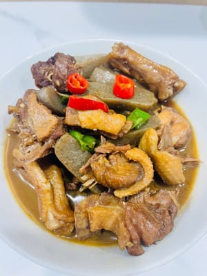 In einem anderen Wok etwas Öl erhitzen und die gewürfelten grünen und roten Chilischoten sowie den gehackten Knoblauch anbraten. Die geschmorte Ente hinzufügen und vor dem Servieren kurz anbraten.