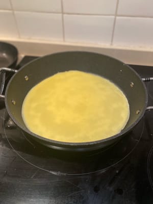 ละลายเนยในกระทะที่ไม่ติดกระทะด้วยไฟปานกลาง ใส่ส่วนผสมครึ่งหนึ่งลงไป แล้วเคลือบให้ทั่วกระทะ