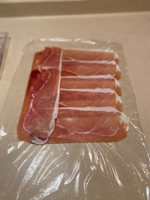 วางแฮมโปรsciutto ลงบนแผ่นพลาสติกห่ออาหารขนาดใหญ่