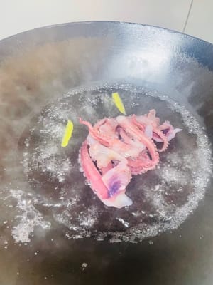 오징어 다리 손질: 오징어 다리를 깨끗이 씻은 후 끓는 물에 30초간 데치고, 생강 조각과 요리용 술을 넣어 비린내를 제거한 다음 건져내어 깨끗이 헹궈 잘게 다져둡니다.