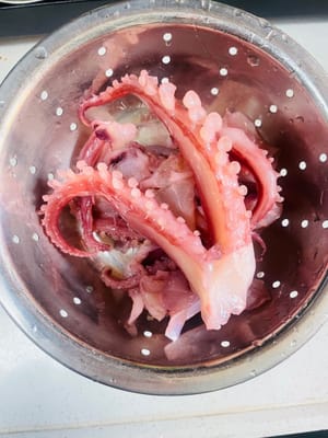 오징어 다리 손질: 오징어 다리를 깨끗이 씻은 후 끓는 물에 30초간 데치고, 생강 조각과 요리용 술을 넣어 비린내를 제거한 다음 건져내어 깨끗이 헹궈 잘게 다져둡니다.