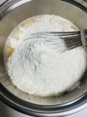 반죽 준비: 볼에 달걀 2개를 깨뜨려 넣고 잘 풀어줍니다. 물을 넣고 잘 섞은 후, 타코야끼 가루를 넣고 매끄러워질 때까지 저어줍니다. 덩어리가 있으면 20분 정도 그대로 두었다가 다시 저어줍니다.

대체 방법: 타코야끼 가루를 구할 수 없는 경우, 다목적 밀가루 200g + 물 200g + 달걀 2개에 소금과 MSG를 약간 넣어 간을 한 후 사용해도 됩니다.

마지막으로, 반죽을 주둥이가 있는 용기에 담아 베이킹 팬에 옮겨 담기 쉽게 합니다.