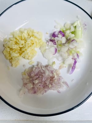 Picar el ajo, la cebolla y la cebolleta en cuadritos pequeños y reservar. Si puede comer chiles, puede agregar algunos.