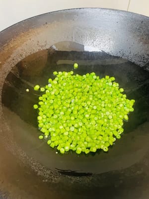 鍋子裡加油，倒入豆角炒至斷生，加入小匙鹽。炒過程中可以分2次，每次加2湯匙水，以便容易炒熟。