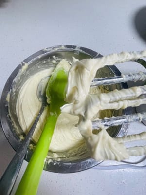 Tambahkan garam dan gula bubuk ke dalam mentega, aduk terlebih dahulu agar bubuk tidak terciprat saat dikocok. Kemudian, terus kocok mentega hingga putih dan mengembang.