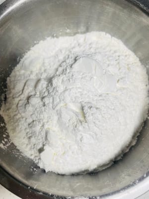 将低筋面粉、玉米淀粉筛入，抓拌（不是揉，否则会揉岀筋）成无颗粒的软面团。