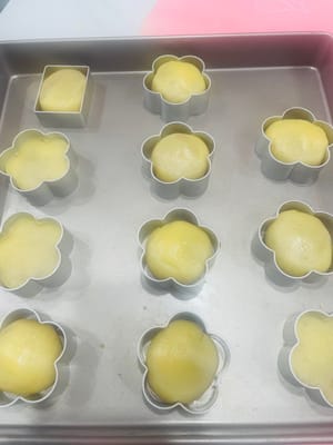 把你包凤梨酥生胚放进模具，在烤盘里操作更稳！用模具压板压一压，别移位变形，不然颜值暴跌。