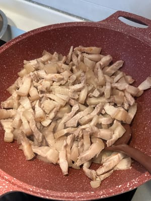 In una padella calda con olio leggero, soffriggere la pancetta di maiale finché l'olio non fuoriesce