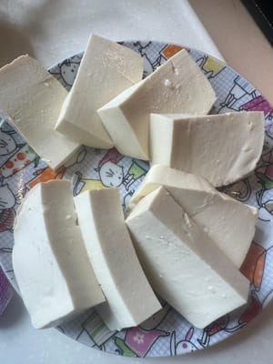 豆腐切好。锅热，下油。放豆腐煎两面少少金黄。