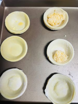 การเตรียมไส้และแป้งพาย: เทไส้ที่พักไว้แล้วลงในแป้งพาย หากมีลูกเกด สามารถใส่ลงไปในไส้ได้หนึ่งลูก