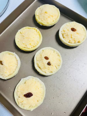 การเตรียมไส้และแป้งพาย: เทไส้ที่พักไว้แล้วลงในแป้งพาย หากมีลูกเกด สามารถใส่ลงไปในไส้ได้หนึ่งลูก