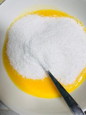 ใส่เนื้อมะพร้าวขูดและคนให้เข้ากัน: ใส่เนื้อมะพร้าวขูด 50 กรัม แล้วคนไปในทิศทางเดียวจนเข้ากันดี