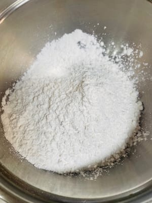 Reismehl und Klebreismehl in einen Behälter geben, Puderzucker hinzufügen (mein Puderzucker war durch schwarzes Sesampulver 