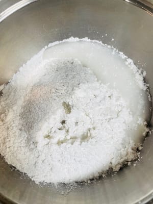 Reismehl und Klebreismehl in einen Behälter geben, Puderzucker hinzufügen (mein Puderzucker war durch schwarzes Sesampulver 