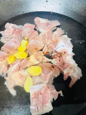 Das Schwein waschen und in einen Topf mit kaltem Wasser geben. Kochwein, Ingwer und Pfefferkörner dazugeben, blanchieren, aus dem Topf nehmen, waschen und beiseite stellen.