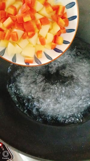 Kartoffeln und Karotten in kochendes Wasser geben und gar kochen.