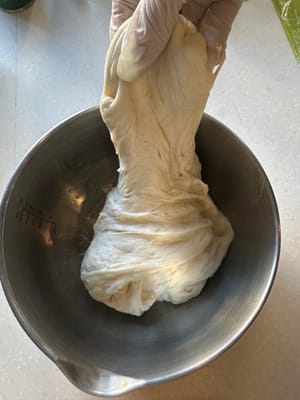 Luego, gira 90 grados y haz lo mismo: estira el borde de la masa en la dirección de las 12 en punto y dóblalo hacia abajo hasta las 6 en punto.