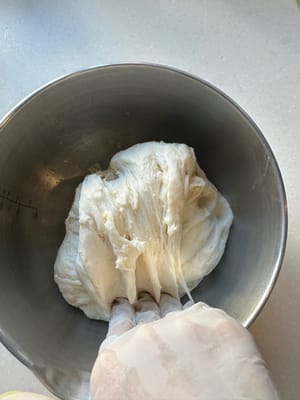 Luego, gira 90 grados y haz lo mismo: estira el borde de la masa en la dirección de las 12 en punto y dóblalo hacia abajo hasta las 6 en punto.