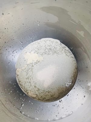Add water and yeast to a bowl and mix well. Then add 500 grams of flour (reserve 80 grams for later use), salt and sugar and knead until the surface is smooth.