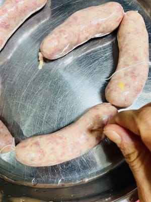 捆綁線及紮透氣孔:
灌一段就用線紮一節(按自己想吃的長度扎,方便後續吃)
紮好後拿牙籤在腸衣上多扎幾個孔(提前排氣,不然加熱時腸衣裡的空氣會把腸撐爆,跟容嬤嬤嬤似的多扎幾下~)